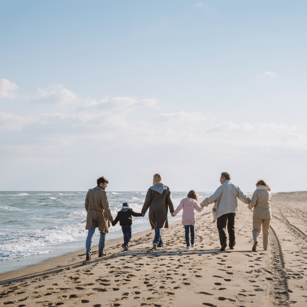 A multi-generational family walking hand-in-hand along a beach, representing unity, legacy, and the benefits of a family trust